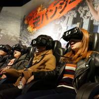 Visitors experience the Ultra Reverse Bungee game with virtual reality headsets and moving seats at Shibuya VR Land in Tokyo. VR amusement center opens in Shibuya to cash in on new tech