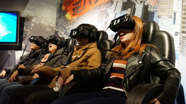 Visitors experience the Ultra Reverse Bungee game with virtual reality headsets and moving seats at Shibuya VR Land in Tokyo. VR amusement center opens in Shibuya to cash in on new tech