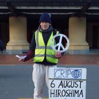 An anti-nuclear activist hands out peace cranes in Wellington on Aug. 6, 2014. Nuclear-free New Zealand turns 30
