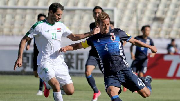 Japan captain Keisuke Honda prepares to shoot as Iraq’s Saad Abdulameer defends during their 1-1 World Cup qualifying draw in Tehran on Tuesday. Japan draws with Iraq to move one win away from World Cup