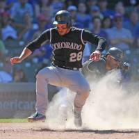 Colorado’s Nolan Arenado scores a run on a wild pitch in the ninth inning of the Rockies’ 9-1 win over the Cubs on Saturday. Rockies beat Cubs for seventh straight win