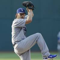 Los Angeles’ Clayton Kershaw prepares to deliver a pitch during the Dodgers’ 7-5 win over the Indians on Tuesday. Kershaw extends win streak as Dodgers take down Indians