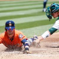 Houston’s Josh Reddick beats the tag of Oakland’s Bruce Maxwell in the first inning on Thursday. Astros complete sweep of Athletics