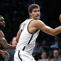 Brooklyn’s Brook Lopez drives past Atlanta’s Tim Hardaway Jr. during their April 2 game in New York. Howard, Lopez on move amid flurry of deals