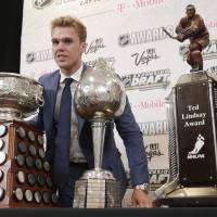 The Oilers’ Connor McDavid poses with the Art Ross Trophy (left), the Hart Memorial Trophy, and the Ted Lindsay Award at the NHL Awards on Wednesday in Las Vegas. Oilers captain McDavid wins Hart Trophy