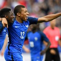 France’s Ousmane Dembele (left) is congratulated by teammate Kylian Mbappe after scoring against England during a friendly at the Stade de France on Tuesday. Dembele winner lifts France past England