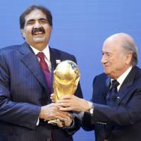 The Emir of Qatar (left) holds the World Cup trophy with then FIFA president Sepp Blatter after being named host of the 2022 tournament in December 2010. Report reveals Japan sent FIFA execs 'gifts' during 2022 World Cup bid race