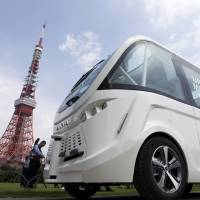 A Navya Arma autonomous shuttle bus moves past Tokyo Tower during a test drive Tuesday. Driverless electric vehicle developed in France completes first test run in Japan