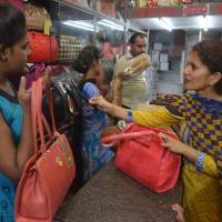 An Indian woman sells a handbag to a customer at a shop in Amritsar on Friday as India braces for its most significant reform in a generation with Saturday’s debut of the Goods and Services Tax (GST). Indians go on shopping frenzy ahead of radical unified sales tax