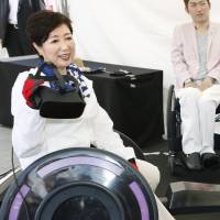 Tokyo Gov. Yuriko Koike experiences wheelchair tennis using virtual reality equipment in Ueno Park in May. Japan's struggling sports sector taps cutting-edge tech to boost popularity