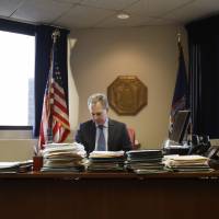 New York State Attorney General Eric Schneiderman sits at his desk in his office in New York in February. Schneiderman’s office considers Secretary of State Rex Tillerson a central figure in his expanding investigation into whether ExxonMobil misled investors about the impact of climate change. Tillerson testimony may be sought in probe into Exxon's alleged misleading of investors