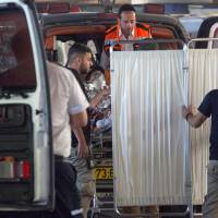 Medics evacuate an Israeli woman who was injured during a knife attack in the Jewish settlement of Neve Tsuf at the West Bank, at a hospital in Jerusalem on Friday. Three Palestinians, three Israelis killed in violence over holy site