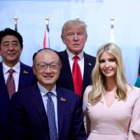 Prime Minister Shinzo Abe stands with World Bank President Jim Yong Kim (from left), U.S. President Donald Trump, Ivanka Trump, German Chancellor Angela Merkel and Canadian Prime Minister Justin Trudeau for a group photo at the Women’s Entrepreneurship Finance event during the Group of 20 leaders summit in Hamburg, Germany, on Saturday. Trump defends Ivanka 'sitting in' at G-20, draws rebuke from Chelsea Clinton