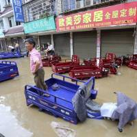 Residents check on a flooded neighborhood in the city of Loudi, in southern China’s Hunan Province, on Saturday. | CHINATOPIX / VIA AP