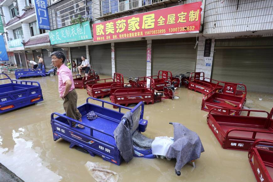Residents check on a flooded neighborhood in the city of Loudi, in southern China’s Hunan Province, on Saturday. Heavy rain in Southern China causes floods, killing at least 56