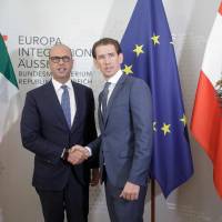 Austrian Foreign Minister Sebastian Kurz (right) and Italian Foreign Minister Angelino Alfano shake hands during a meeting in Vienna Thursday. Austria tells Italy to halt island ferries in order to keep migrant masses off mainland