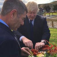 British Foreign Secretary Boris Johnson eats crayfish with New Zealand Civil Defense Minister Nathan Guy during a visit to the township of Kaikoura, on New Zealand’s South Island, on Monday. British minister jokes about traditional New Zealand Maori greeting