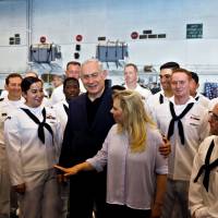 Israeli Prime Minister Benjamin Netanyahu and his wife, Sara, chat with American sailors during a visit on the aircraft carrier USS George H. W. Bush, as it anchors at Haifa port, Israel, Monday. U.S. carrier in Mediterranean wary of 'tensions' with Assad's allies