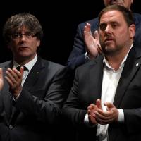 President of the Catalan regional government Carles Puigdemont (left) and Catalan regional Vice President and chief of Economy and Finance Oriol Junqueras applaud as they present the details of the referendum of self-determination of Catalonia to be held on Oct. 1, during a conference dubbed “Garanties.cat” in Barcelona on Tuesday. Despite Madrid's opposition, Catalonia to declare immediate independence if 'yes' wins referendum