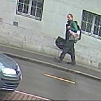 This handout picture released Monday by Swiss Police of the Canton of Schaffhausen (Schaffhauser Polizei) shows the man who injured at least five people with a chainsaw in an attack in the old town of Schaffhausen purportedly holding a bag containing the chainsaw. Swiss manhunt on for 'psychologically disturbed' chainsaw-wielding attacker who wounded five at health insurer