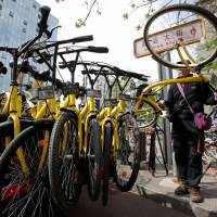 A worker for the bike-sharing company Ofo gathers bicycles ahead of the evening rush hour, in Beijing on April 12. Need to borrow a ball or umbrella? In China, there's an app for that