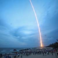 People watch the launch of the Long March-5 Y2 rocket from Wenchang Satellite Launch Center in Wenchang, Hainan Province, China, Sunday. China reports 'unsuccessful' launch of rocket carrying communication satellite