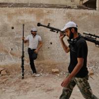 Syrian rebel fighters from the Faylaq al-Rahman brigade carry their homemade 12.7mm sniper rifle in Ain Tarma, in the eastern Ghouta area, a rebel stronghold east of the capital Damascus, on Thursday. 28 government troops killed in ambush near Damascus