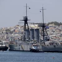 Tugs pull the 107-year-old battleship Georgios Averof to Trocadero marina in southern Athens on Wednesday. After three months of extensive maintenance and conservation work, a relic of the era of dreadnoughts is back in its berth in Athens, where it serves as a floating museum. 107-year-old dreadnought returns to Athens berth after repairs