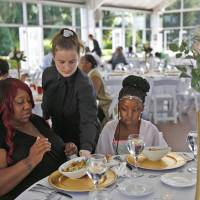 Katelin Decraene (center) gives Trishell Crawford and her daughter, Jacqueline Crawford, from Dayspring, salads at a reception at the Ritz Charles in Carmel, Indiana, Saturday. Sarah Cummins called off her wedding, which was supposed to be this day. Cummins decided to bring purpose to the couple’s pain by inviting area homeless to enjoy the reception. Woman drops wedding but can't duck $30,000 dinner tab so gives Indiana homeless feast