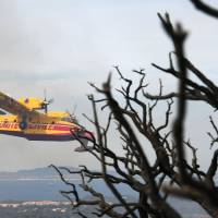 A Canadair firefighting plane prepares to release water on Thursday in Bormes-les-Mimosas, southeastern France. French crews get control of massive wildfire along Mediterranean as winds ease but yet to declare all-clear