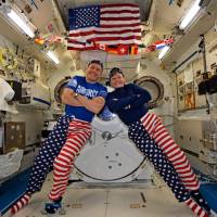 This NASA handout photo shows NASA astronauts Jack Fischer and Peggy Whitson celebrating the Fourth of July from over 250 miles above Earth on the International Space Station on Tuesday. Fischer shared this photo on social media and said, “We sometimes have issues standing up straight, but we have no problems at all showing our American pride-Happy 4th!” Americans mark 241st Independence Day with pomp, pyrotechnics, dazzle, hot dog contest and tight security