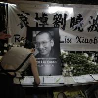 A protester signs a condolence book for jailed Chinese Nobel Peace laureate Liu Xiaobo during a demonstration outside the Chinese liaison office in Hong Kong on Thursday. Government officials in the northeast Chinese city of Shenyang said the same day that Liu had died from liver cancer. Late Chinese Nobel Peace Prize winner Liu Xiaobo 'had no enemies, no hatred'