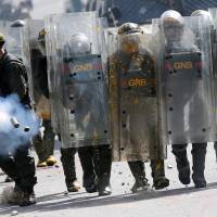 Riot security forces fire tear gas during clashes at a rally against Venezuelan President Nicolas Maduro’s government in Caracas Tuesday. Defying Trump's 'brutal interventionist' threat, Maduro to press ahead with Constituent Assembly
