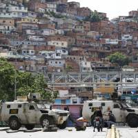 Bolivarian National Guard frces stand guard outside the Petare shantytown in Caracas Thursday. Large swaths of Venezuela’s capital were shuttered and silent Thursday as opponents of President Nicolas Maduro called a major national strike as an expression of disapproval of his plan to convene a constitutional assembly that would reshape the Venezuelan system to consolidate the ruling party’s power over the few institutions that remain outside its control. Maduro threatens punishment as Venezuelans stage national strike