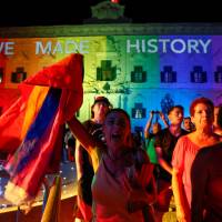 People celebrate in front of the rainbow-color-lit Auberge de Castille, the office of Prime Minister Joseph Muscat, after the Maltese parliament voted to legalize same-sex marriage on the Roman Catholic Mediterranean island, in Valletta Wednesday. Conservative Malta becomes 24th nation to legalize same-sex marriage