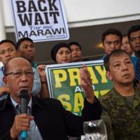Philippine Defense Secretary Delfin Lorenzana speaks while Lt. Gen. Carlito Galvez, Western Mindanao military commander, listens during a dialogue between displaced Marawi residents and government officials in Iligan City on the southern island of Mindanao on Sunday. Duterte says he can wait a year for Marawi standoff to end, wants to minimize civilian deaths