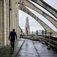 A man inspects the arches on the roof of Notre Dame on June 28. Paris' Notre Dame Cathedral needs urgent repairs