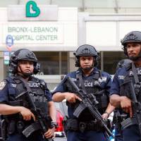 Police officers patrol the scene after a shooting incident Friday inside the Bronx-Lebanon Hospital Center in New York City. One person dead, six hurt as former doctor at New York hospital goes on shooting rampage