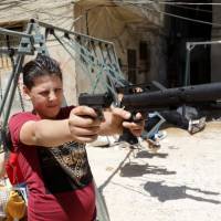 A Syrian boy holds a toy gun as he plays in the Shatila Palestinian refugee camp, on the southern outskirts of the Lebanese capital, Beirut, on June 25. U.N. cites 'notable trend' of people returning home in Syria