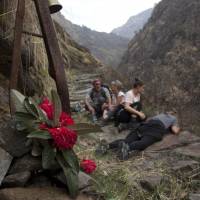 Elizabeth Brenner (third from right) and her family sit at the spot on the Milam Glacier Trail on March 27 where Brenner’s son, Thomas Plotkin, slipped and fell down a steep gorge and into the raging Goriganga River in 2011. U.S. parents find it hard to get answers when children's studies abroad ends in death or injury