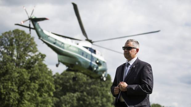A U.S. Secret Service agent stands as Marine One, with U.S. President Donald Trump and first lady Melania Trump on-board, departs the South Lawn of the White House in Washington on Tuesday. House in 419-3 vote passes veto-proof Russia, Iran and North Korea sanctions bill