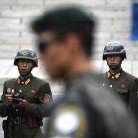 Two North Korean soldiers look at the south side as a South Korean soldier stands guard during U.S. Vice President Mike Pence’s April visit to the border village of Panmunjom that has separated the two Koreas since the Korean War. South Korea seeks rare talks with North to ease soaring military tensions