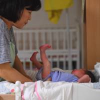 A social worker cares for a baby at the Jusarang Community Church in southern Seoul in May. South Korean child protection law sees more abandoned babies