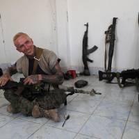 Kevin Howard, a 28-year old former U.S. military contractor from California, who fights with an Assyrian militia — part of the U.S-backed forces battling Islamic State group militants — gives an interview in Raqqa, Syria, on July 17. U.S., British volunteers battle Islamic State in militants' de facto Syrian capital