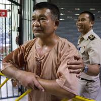 Lt. Gen. Manas Kongpaen of the Royal Thai Army is escorted by a Thai correction officer on his arrival last year at the Criminal Court in Bangkok. The Thai army general was one of the most prominent figures found guilty Wednesday in a major human trafficking trial that included more than 103 defendants accused of involvement in a modern-day slave trade. Thailand convicts 62 in trafficking case, after more than 30 bodies — believed to be Rohingya — were found