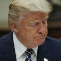 President Donald Trump pauses while having lunch with service members in the Roosevelt Room of the White House in Washington Tuesday. Trump lets Iran nuke deal stand but signals that could change soon, adds sanctions