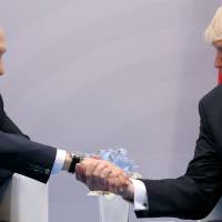 U.S. President Donald Trump shakes hands with Russian President Vladimir Putin during the their bilateral meeting at the G-20 summit in Hamburg, Germany, July 7. Trump, Putin spoke in previously undisclosed dialogue at G-20 dinner