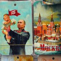 A drawing of Russian President Vladimir Putin holding a baby with the face of U.S. President Donald Trump, based upon a propaganda poster showing late Soviet leader Joseph Stalin holding a baby, is displayed at a souvenir kiosk in Moscow on Wednesday. Trump-Putin talks raise fears ex-spymaster to get upper hand