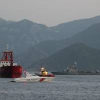 The Turkish freighter M/V ACT is escorted by a Turkish Coast Guard boat as it arrives at Marmaris port, Turkey, Monday. Turkey slams 'excessive act' after Greek coast guard fires on freighter off Rhodes