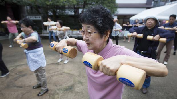 A woman exercises with wooden dumbbells during an event marking Respect for the Aged Day at a temple in Tokyo on Sept. 19. A group of researchers is proposing redefining elderly to age 75 and older, saying senior citizens are rejuvenated compared with decades ago. Thanks to 'rejuvenation,' definition of elderly should go up 10 years, Japanese researchers say